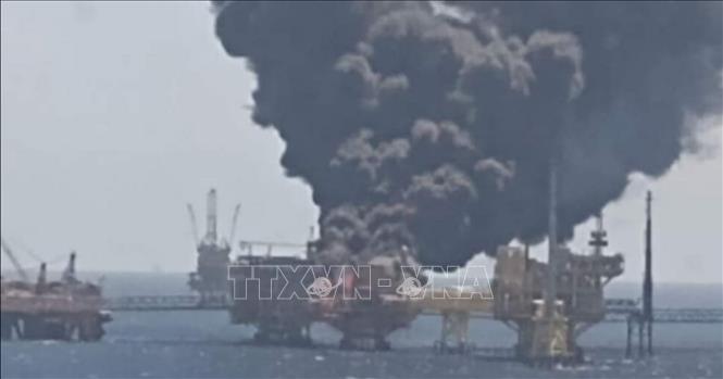 Nổ giàn khoan dầu ngoài khơi Vịnh Mexico Khói bốc ngùn ngụt tại hiện trường vụ nổ gây cháy trên giàn khoan dầu Ku-Alpha ở mỏ dầu Ku-Maloob-Zaap, ngoài khơi bờ biển Tabasco và Campeche trên Vịnh Mexico, ngày 23-8-2021. Ảnh: Twitter/TTXVN