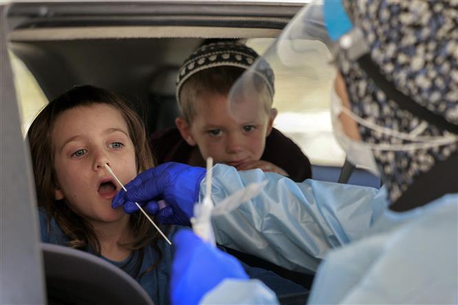 Nhân viên y tế lấy mẫu xét nghiệm COVID-19 cho một em nhỏ tại Jerusalem ngày 29-7-2021. Ảnh: AFP/TTXVN
