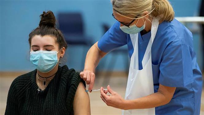 Nhân viên y tế tiêm vaccine ngừa COVID-19 cho người trẻ tuổi ở London, Anh ngày 25-6-2021. Ảnh: Getty Images/TTXVN