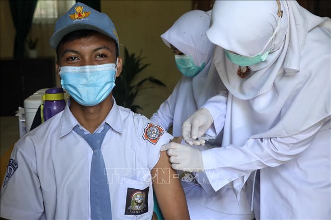 Nhân viên y tế tiêm vaccine COVID-19 cho trẻ vị thành niên tại Aceh, Indonesia, ngày 30-8-2021. Ảnh: AFP/TTXVN