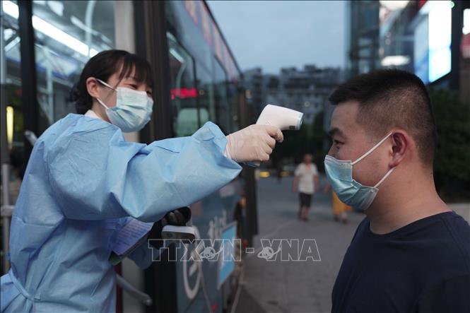 Người dân được kiểm tra thân nhiệt trước khi vào một điểm tiêm chủng ngừa COVID-19 ở Trùng Khánh, Trung Quốc ngày 20-8-2021. Ảnh minh họa: THX/TTXVN