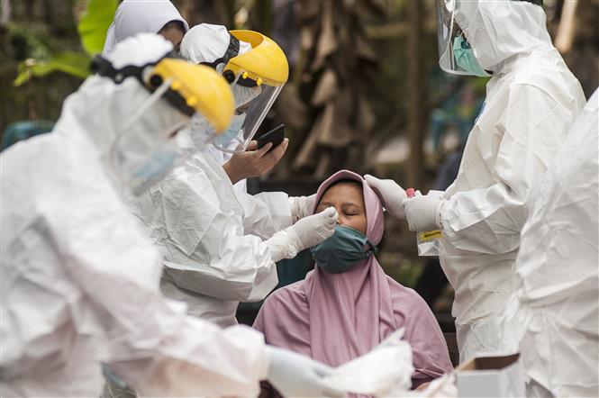 Nhân viên y tế lấy mẫu xét nghiệm COVID-19 cho người dân tại Yogyakarta, Indonesia, ngày 14-6-2021. Ảnh: THX/ TTXVN