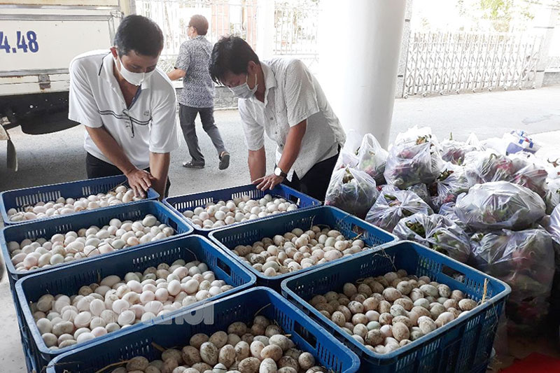 Nhiều cá nhân tiêu biểu trong thi đua “Đồng khởi mới” phòng chống dịch Covid-19 Tiếp nhận và phân phối quà hỗ trợ để trao tặng cho người dân. Ảnh: T. Huyền