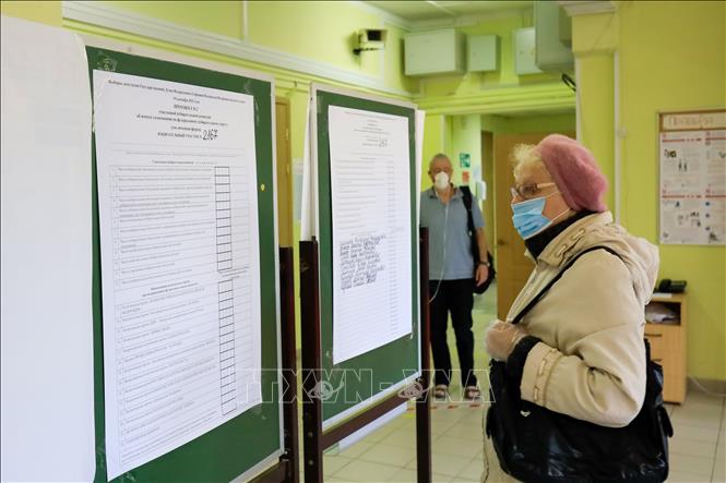Cử tri theo dõi thể lệ bầu cử và danh sách ứng viên được niêm yết công khai. Ảnh: Duy Trinh/PV TTXVN tại Nga