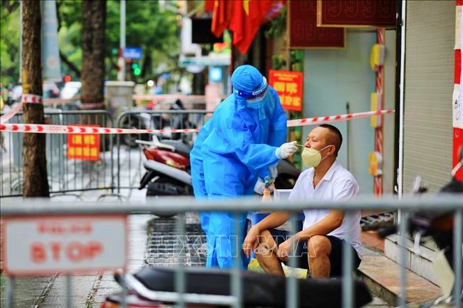 Lấy mẫu xét nghiệm COVID-19 cho người dân ở khu vực có nguy cơ cao. Ảnh: TTXVN