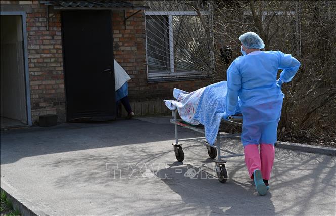 Chuyển bệnh nhân tử vong do nhiễm COVID-19 tới nhà xác bệnh viện ở Kiev, Ukraine. Ảnh: AFP/TTXVN