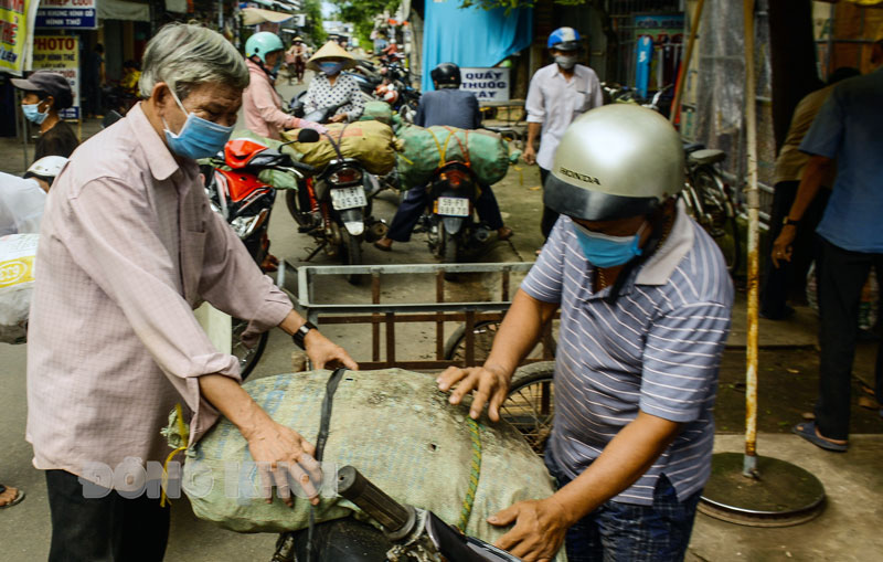 Cụ Trần Văn Thứ (thứ nhất bên trái) hỗ trợ khoai lang cho người dân xã Bình Khánh.