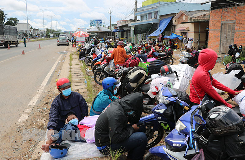 Người dân Trà Vinh giữa đường mắc mưa và chờ khoảng 2 tiếng dưới nắng tại chốt cầu Rạch Miễu để được đưa về quê.