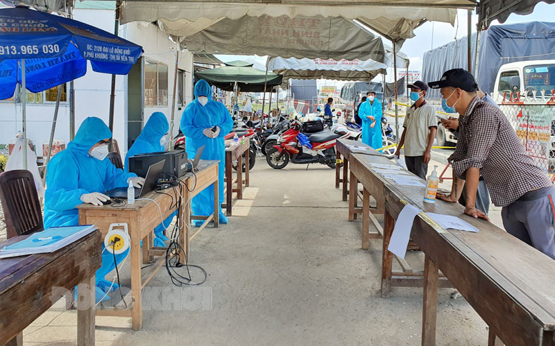 Người dân thực hiện khai báo y tế tại chốt kiểm soát dịch cầu Rạch Miễu. Ảnh Thanh Đồng