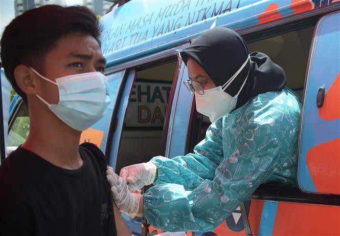 Thêm 6.860 người chết, Mỹ tăng gấp đôi ca tử vong mới Nhân viên y tế tiêm vaccine phòng COVID-19 cho người dân tại Jakarta, Indonesia, ngày 24-9-2021. Ảnh: THX/ TTXVN