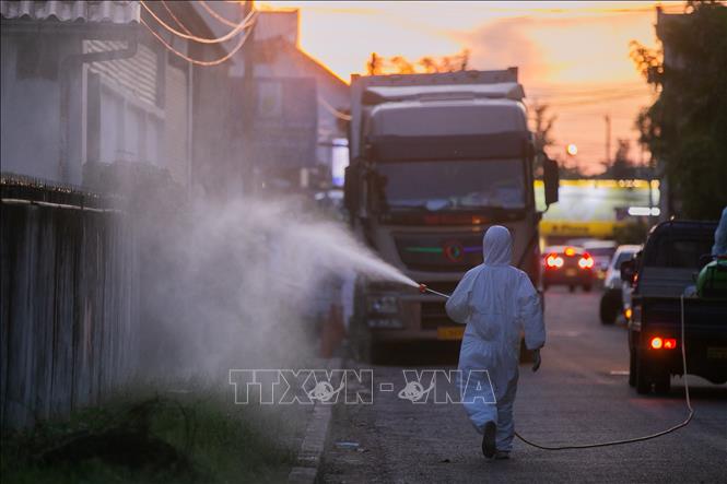 Nhân viên y tế phun thuốc khử trùng nhằm ngăn chặn sự lây lan của dịch COVID-19 tại Viêng Chăn, Lào, ngày 30-9-2021. Ảnh: THX/TTXVN