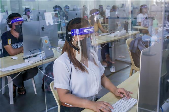 Nhân viên đeo khẩu trang, sử dụng tấm nhựa chắn phòng lây nhiễm COVID-19 tại văn phòng ở Taguig, Philippines, ngày 15-9-2021. Ảnh: THX/TTXVN