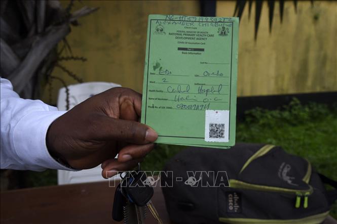 Một nhân viên xuất trình giấy chứng nhận tiêm chủng tại Benin, Nigeria, ngày 16-9-2021. Ảnh: AFP/TTXVN