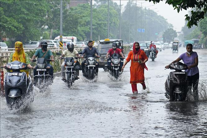Người dân di chuyển trên tuyến đường ngập lụt do mưa lớn tại Amritsar, Ấn Độ ngày 10-7-2021. Ảnh tư liệu: AFP/TTXVN