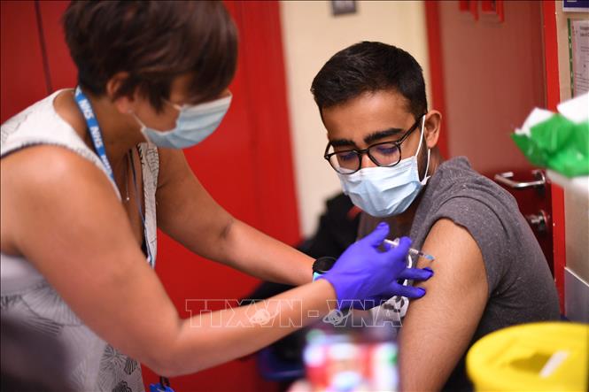 Nhân viên y tế tiêm vaccine Pfizer/BioNTech ngừa COVID-19 cho học sinh tại London, Anh ngày 5-6-2021. Ảnh: AFP/TTXVN