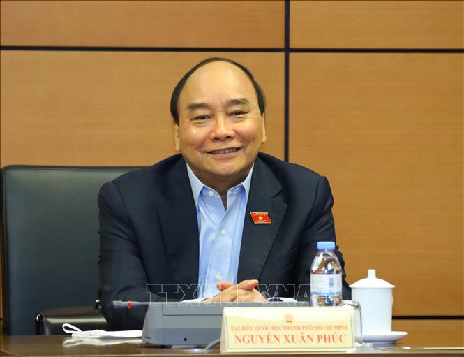 Khen thưởng cần đúng người, đúng việc Chủ tịch nước Nguyễn Xuân Phúc, Đại biểu Quốc hội Thành phố Hồ Chí Minh thảo luận ở tổ. Ảnh: Văn Điệp/TTXVN