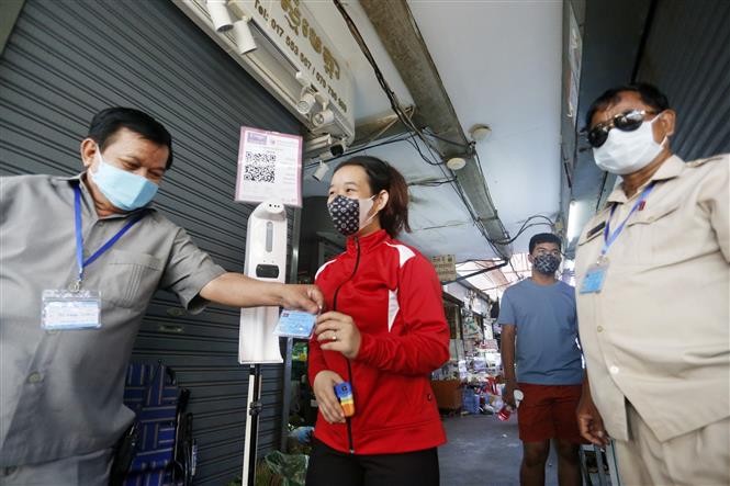 Kiểm tra thẻ tiêm phòng COVID-19 của người dân tại một khu chợ ở Phnom Penh, Campuchia, ngày 11-10-2021. Ảnh: THX/ TTXVN