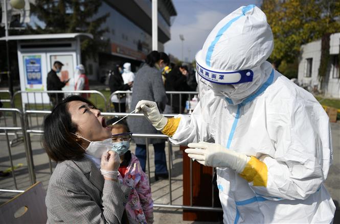 Nhân viên y tế lấy mẫu xét nghiệm COVID-19 cho người dân tại Ngân Xuyên, khu tự trị Ninh Hạ, Trung Quốc, ngày 23-10-2021. Ảnh: THX/ TTXVN