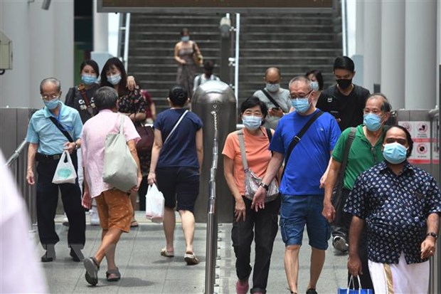 Người dân đeo khẩu trang phòng lây nhiễm COVID-19 tại ga tàu điện ngầm ở Singapore. Ảnh: THX/TTXVN