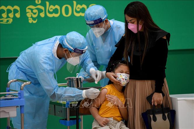 Ca mắc, tử vong mới ở Nga cao nhất thế giới; Dịch lan nhanh ở Trung Quốc Nhân viên y tế tiêm vaccine ngừa COVID-19 cho một em nhỏ tại Phnom Penh, Campuchia ngày 17-9-2021. Ảnh: AFP/TTXVN