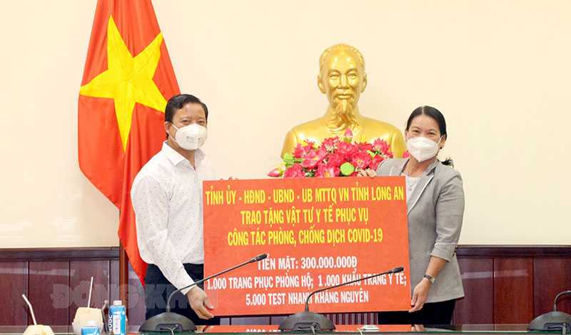 Phó chủ tịch UBND tỉnh Nguyễn Thị Bé Mười tiếp nhận hỗ trợ từ Phó chủ tịch UBND tỉnh Long An Phạm Tấn Hòa.  