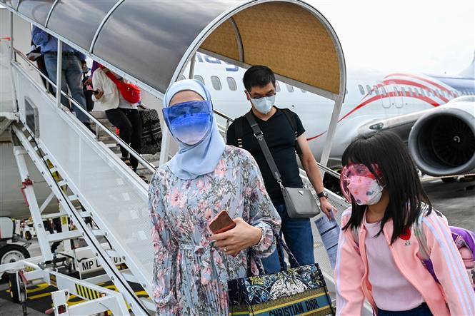 Hành khách đeo khẩu trang phòng lây nhiễm COVID-19 tại sân bay ở Langkawi, Malaysia, ngày 16-9-2021. Ảnh: AFP/TTXVN