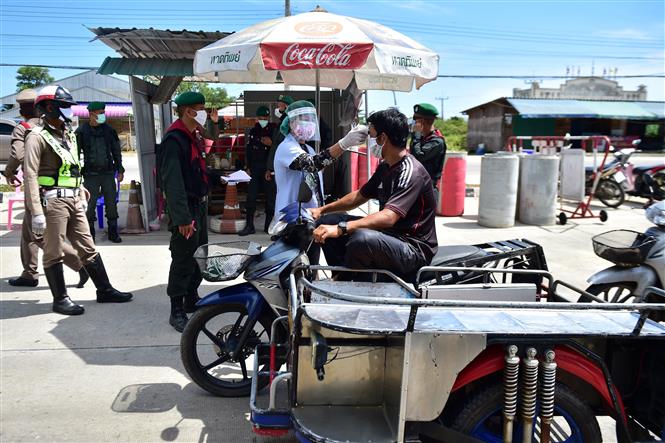 Nhân viên y tế kiểm tra thân nhiệt của người dân tại trạm kiểm soát ở Rimnam, tỉnh Narathiwat, Thái Lan. Ảnh: AFP/ TTXVN