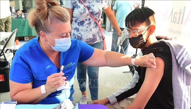 Thế giới thêm 379.000 ca mắc; Ca tử vong mới ở Nga cao nhất Nhân viên y tế tiêm vaccine ngừa COVID-19 cho người dân tại Los Angeles, bang California, Mỹ ngày 17-8-2021. Ảnh: AFP/TTXVN