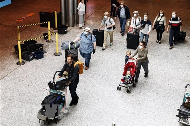 Hành khách đeo khẩu trang phòng lây nhiễm COVID-19 tại sân bay Canada. (Ảnh: AFP/TTXVN)