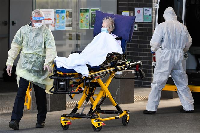 Nhân viên y tế chuyển bệnh nhân COVID-19 tại Melbourne, Australia. Ảnh: AFP/ TTXVN