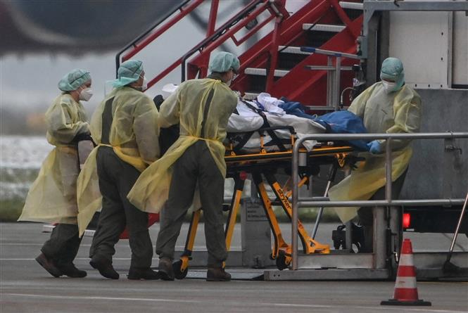 Nhân viên y tế chuyển bệnh nhân COVID-19 bằng máy bay của quân đội, tại sân bay Memmingen, Bavaria, miền Nam Đức ngày 26/11/2021. Ảnh: AFP/TTXVN