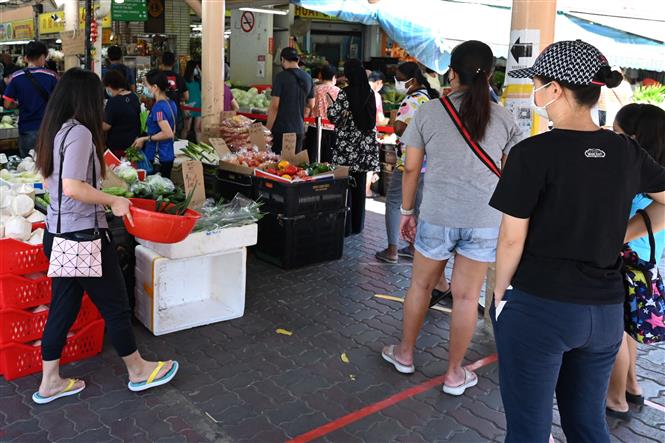 Người dân xếp hàng chờ tới lượt vào chợ để phòng lây nhiễm COVID-19 tại Singapore, ngày 9-10-2021. Ảnh: ÀPF/ TTXVN