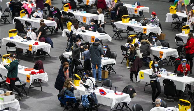 Nhân viên y tế tiêm vaccine phòng COVID-19 cho người dân tại Toronto, Canada, ngày 12-12-2021. Ảnh: THX/ TTXVN