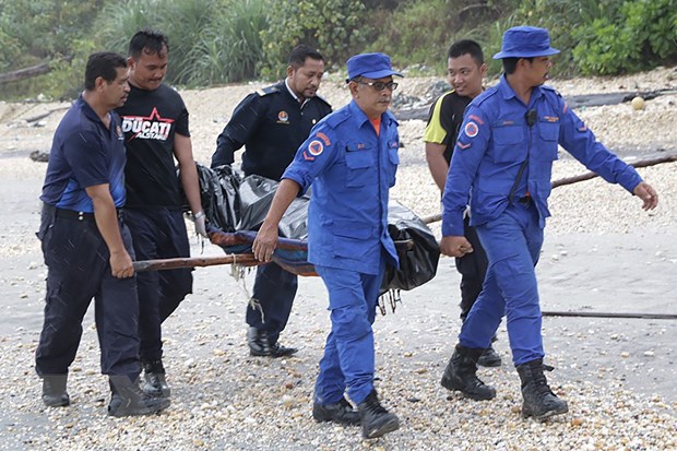 Lực lượng cứu hộ chuyển thi thể một nạn nhân vụ chìm tàu ở Mersing, bang Johor, Malaysia. (Ảnh: AFP/TTXVN)