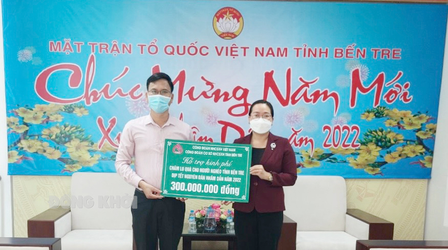 Phó giám đốc Chi nhánh NHCSXH tỉnh Nguyễn Mạnh Hoài (bên trái) trao biểu trưng cho Ủy ban MTTQ Việt Nam tỉnh Bến Tre.