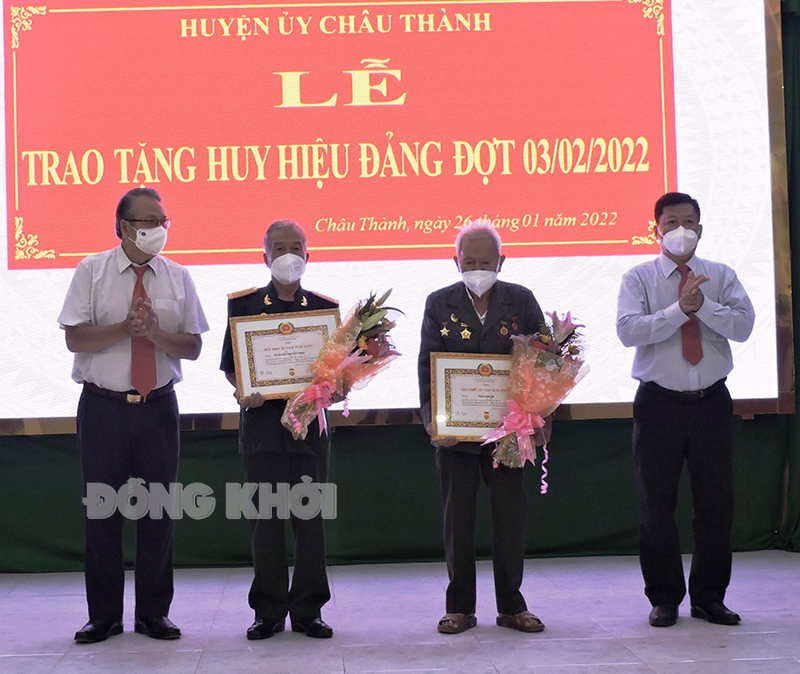 Trưởng ban Tuyên giáo Tỉnh ủy Cao Văn Dũng (bài trái), Bí thư Huyện ủy Phan Song Toàn (bìa phải) trao Huy hiệu Đảng cho các đảng viên đến niên hạn.