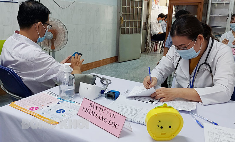 Cán bộ y tế tư vấn sàng lọc trước tiêm chủng.