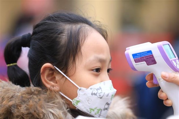 Khẩn trương hướng dẫn phác đồ điều trị COVID-19 cho trẻ dưới 12 tuổi Kiểm tra thân nhiệt cho học sinh. Nguồn: TTXVN