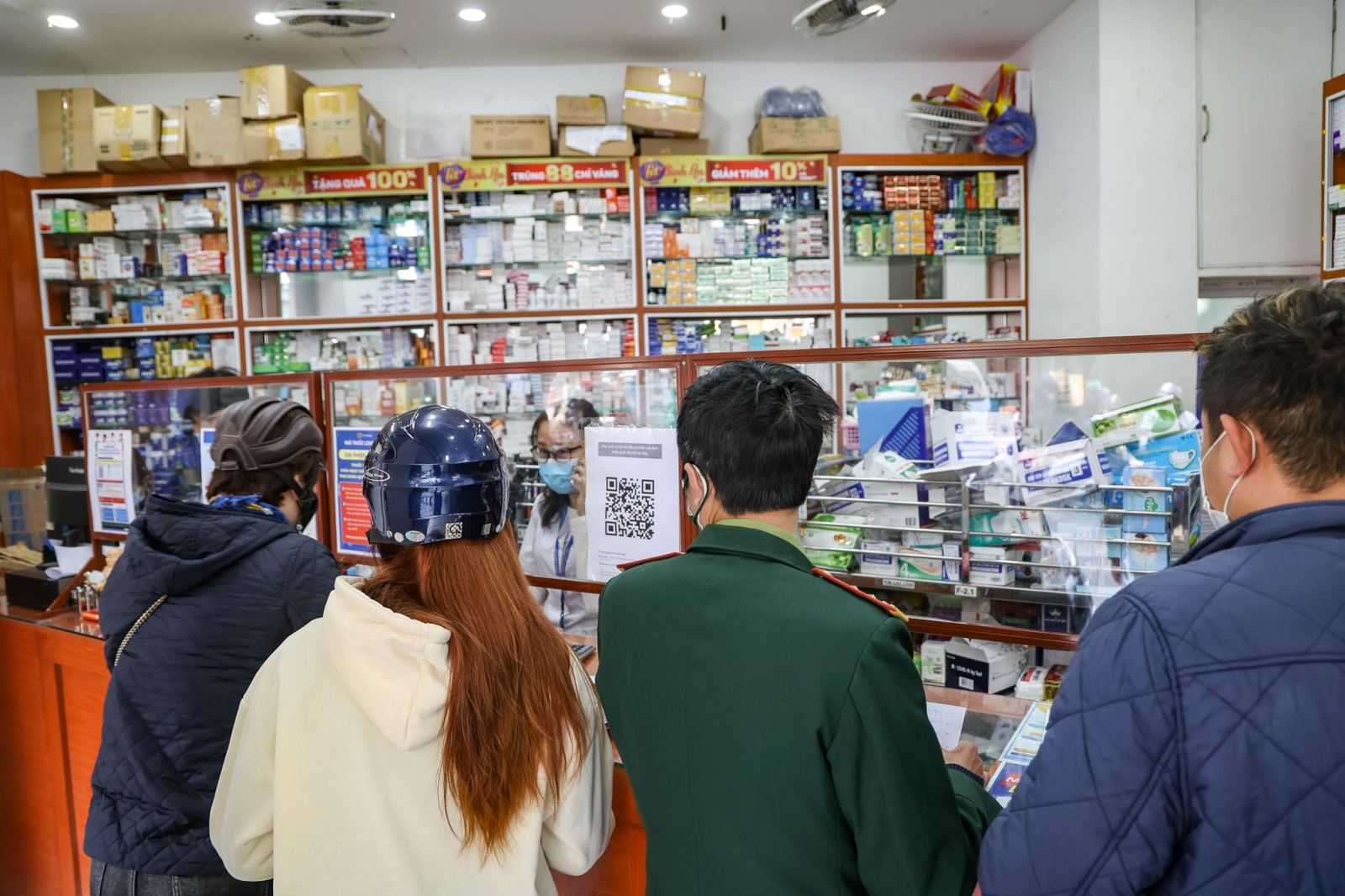 Người dân đi mua thuốc điều trị COVID-19. Ảnh: TTXVN