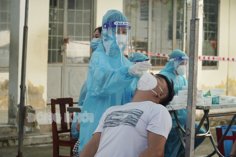 Cán bộ y tế test nhanh tầm soát Covid-19.