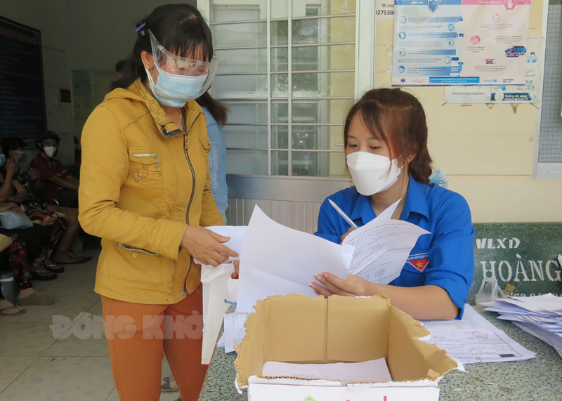 Huỳnh Thị Mỹ Linh hướng dẫn, hỗ trợ người dân tiêm ngừa tại Trạm y tế xã Tân Bình.