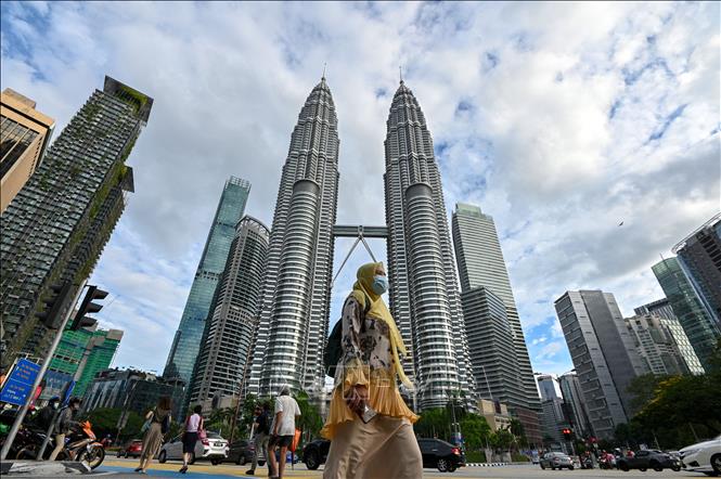 Malaysia mở cửa trở lại biên giới cho du khách quốc tế từ ngày 1-4 Người dân đeo khẩu trang phòng lây nhiễm COVID-19 tại Kuala Lumpur, Malaysia. Ảnh: THX/TTXVN