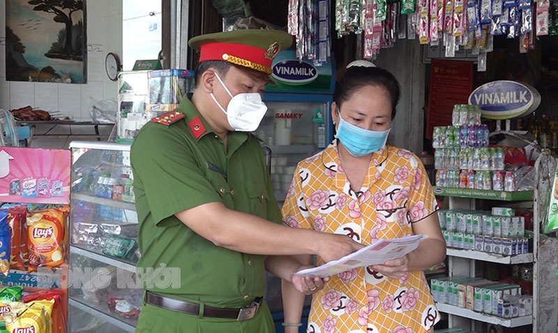 Công an xã Quới Thành, huyện Châu Thành hướng dẫn tiểu thương nhận dạng tiền giả. Ảnh: Minh Tân