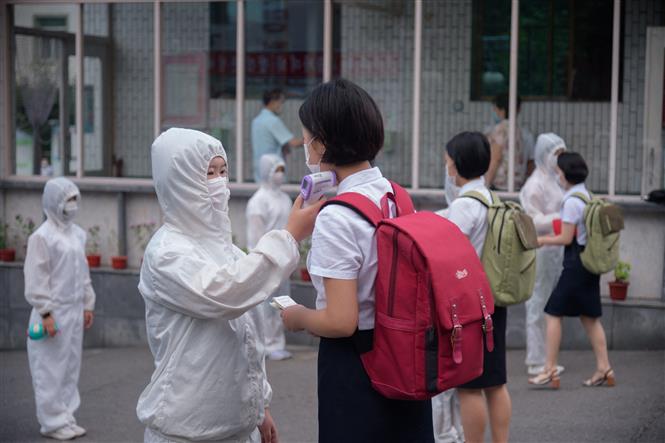 Kiểm tra thân nhiệt nhằm ngăn chặn sự lây nhiễm của dịch COVID-19 tại một trường học ở Bình Nhưỡng, Triều Tiên. Ảnh: AFP/TTXVN