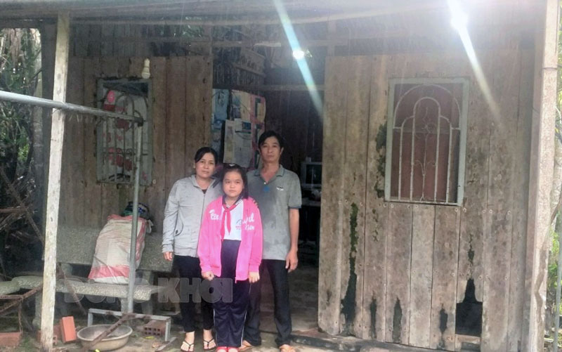 Gia đình anh Nguyễn Thanh Tuấn bên căn nhà đã xuống cấp. Ảnh: H. Trâm