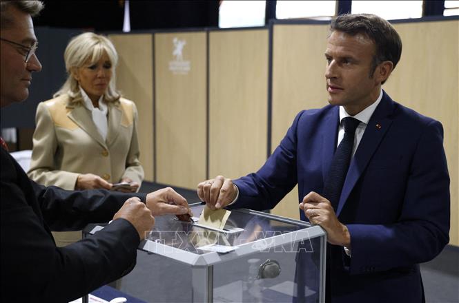 Tổng thống Pháp Emmanuel Macron (phải) cùng phu nhân Brigitte Macron bỏ phiếu bầu cử Quốc hội Khóa XVI tại Le Touquet, ngày 12-6-2022. Ảnh: AFP/TTXVN