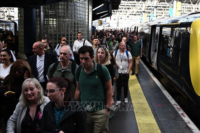 Hành khách rời khỏi tàu tại nhà ga Waterloo ở thủ đô London, Anh, khi các công nhân tiến hành đình công kêu gọi tăng lương, ngày 21-6-2022. Ảnh: AFP/TTXVN
