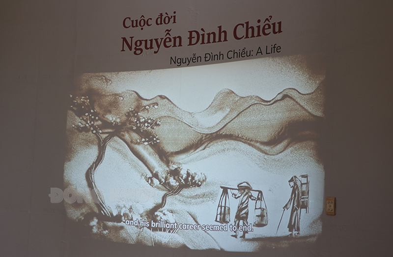 Vẽ tranh cát về cuộc đời cụ Nguyễn Đình Chiểu trên đường về chịu tang mẹ được chiếu bằng máy chiếu sống động.