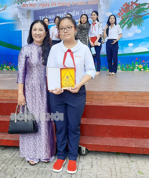 Nguyễn Huỳnh Minh Như và cô chủ nhiệm chụp ảnh lưu niệm năm cuối cấp THCS.
