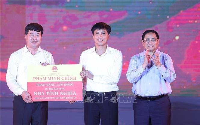 Thủ tướng Phạm Minh Chính dự Chương trình nghệ thuật "Bản hùng ca bất diệt" Thủ tướng Phạm Minh Chính trao cho đại diện huyện Anh Sơn kinh phí hỗ trợ xây dựng nhà tình nghĩa cho 20 gia đình thương binh, liệt sĩ. Ảnh: Dương Giang/TTXVN